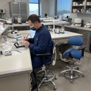technician sits on stool in laboratory